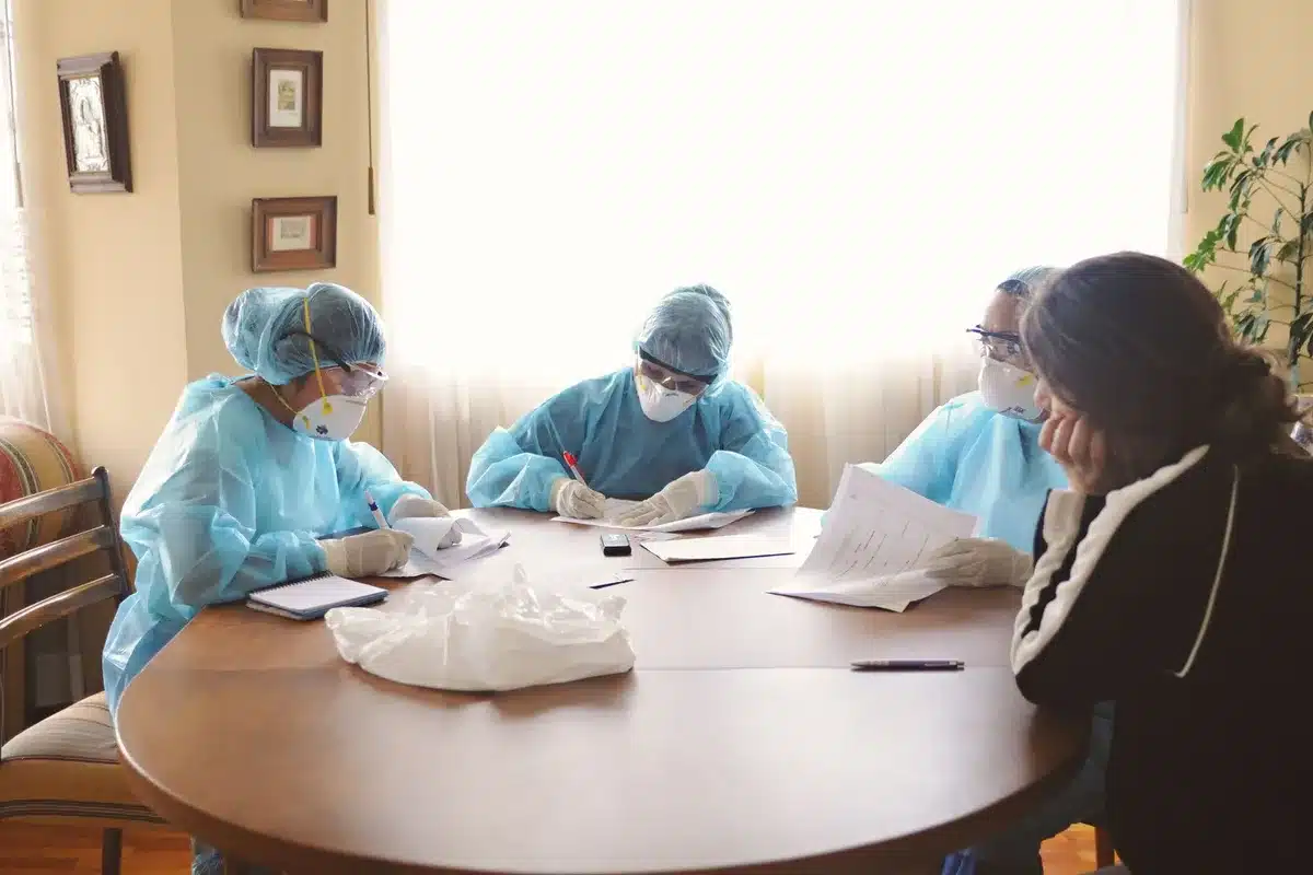 Réunion de professionnels de santé en salle, mains et documents visibles