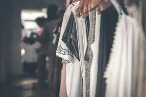 Mains ajustant un blazer en velours dans une boutique baignée de lumière du jour