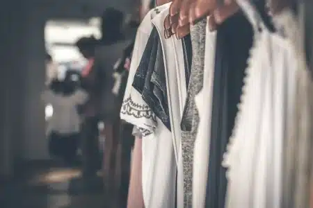 Mains ajustant un blazer en velours dans une boutique baignée de lumière du jour