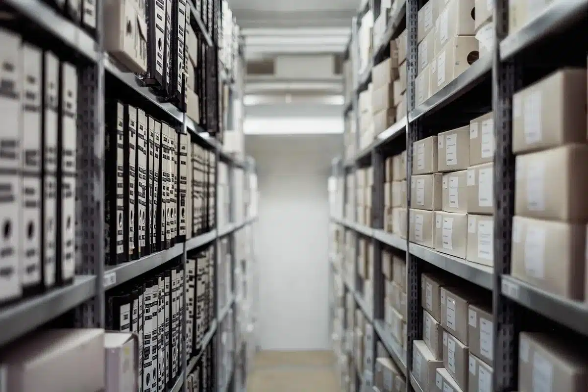 Entrepôt de vêtements d'occasion empilés sur palettes illustrant les volumes vendus